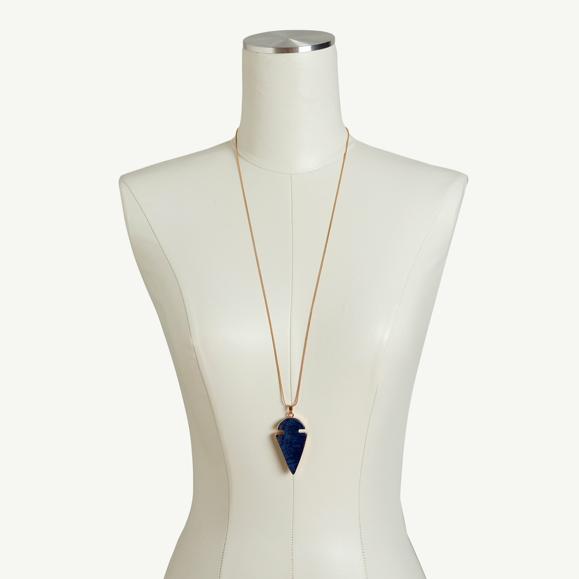 Arrow shaped blue necklace on dress form.