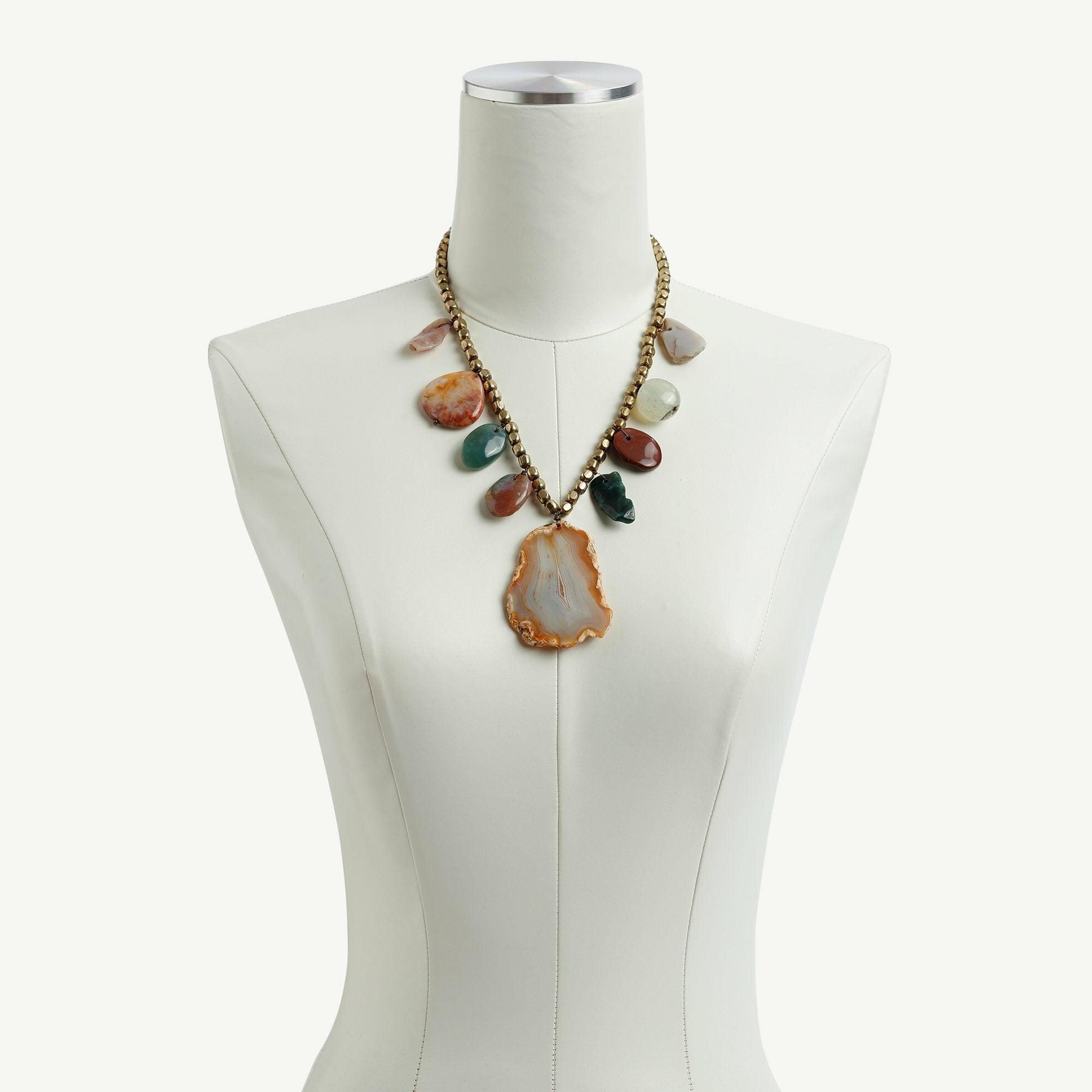 Natural stone necklace on dress form.