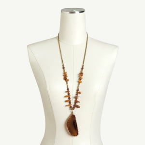 Brown natural stone necklace on a dress form.