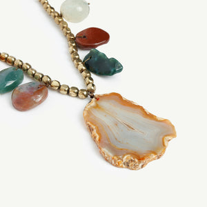 Necklace with small natural stones and a big stone in the middle attached to the beaded chain. 