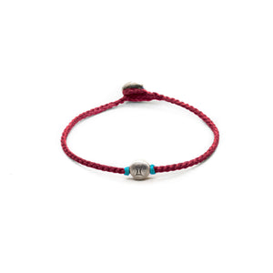 Silver Gemini zodiac sign bracelet with red hand braided chain.