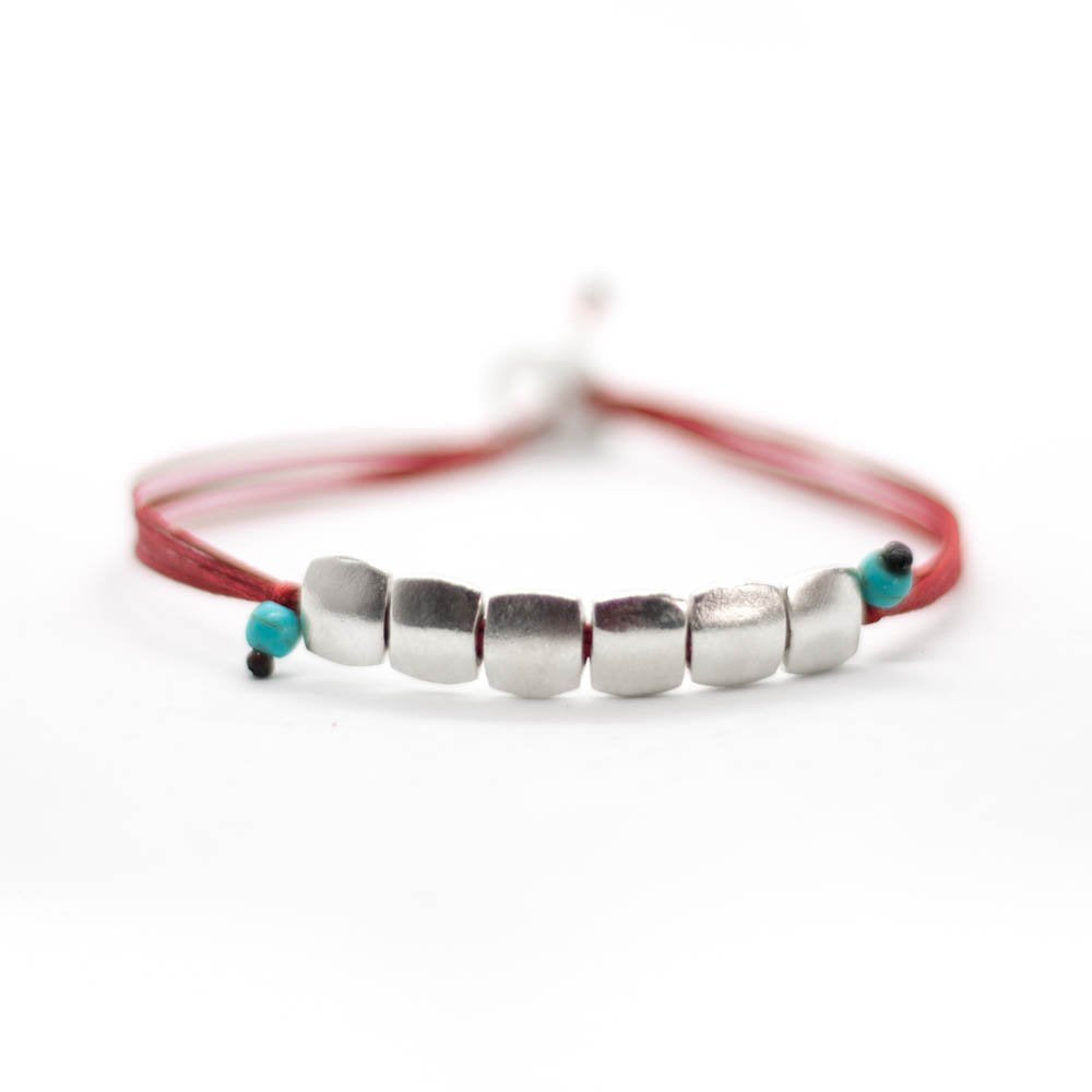 Custom design bracelet with red string with 6 square silver beads ending with two little turquoise beads.